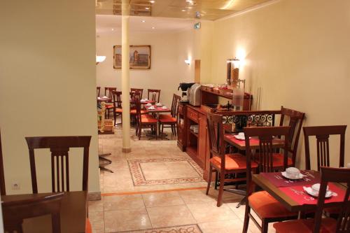 a restaurant with tables and chairs in a room at Metropol in Paris