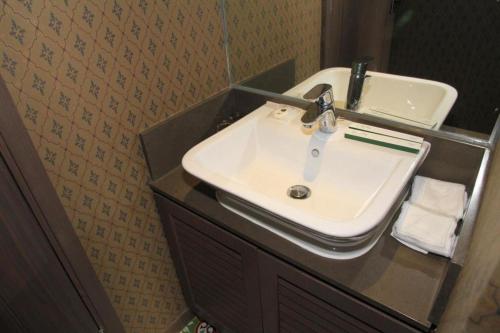 a bathroom with a white sink on a counter at Largos Hotel in Hong Kong