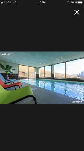 - une grande piscine dans un bâtiment doté de fenêtres dans l'établissement Grand appartement piscine, à Besse-et-Saint-Anastaise