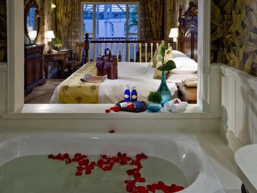 a bathroom with a tub with red flowers in it at Hangzhou The First World Hotel in Hangzhou