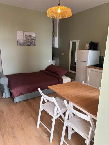 une pièce avec une table, des chaises et un lit dans l'établissement Le T2 des rives, à Bayon