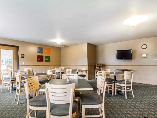 a dining room with tables and chairs and a tv at Quality Inn in Edgerton