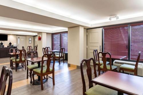 a dining room with tables and chairs and windows at Quality Inn in Manassas