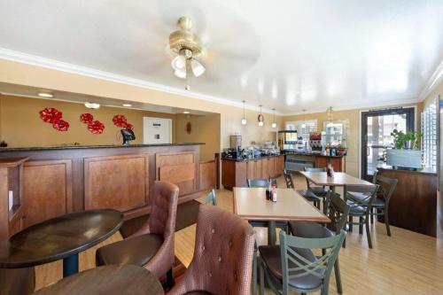 a restaurant with tables and chairs and a bar at Best Western Hanford Inn in Hanford