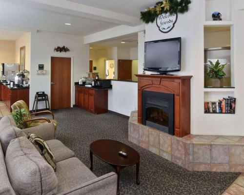 a living room with a fireplace and a tv at Comfort Inn & Suites in Riverton