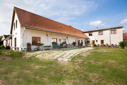 a large white house with a grass yard in front of it at Penzion u lípy in Suchdol nad Lužnicí