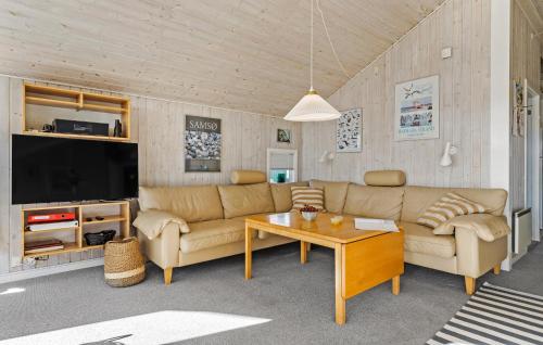 3 Bedroom Cozy Home In Otterup في Otterup: غرفة معيشة بها أريكة وطاولة