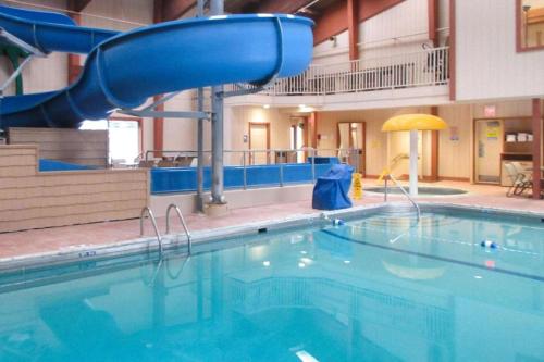 a swimming pool with a slide in a building at Quality Inn & Suites Detroit Lakes in Detroit Lakes