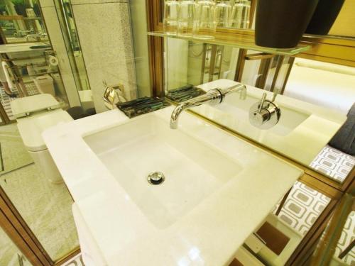 a white sink in a bathroom with a toilet at King's Hotel in Hong Kong
