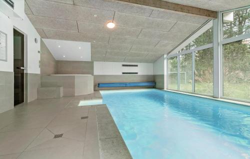 a swimming pool in a house with a large window at Gorgeous Home In Knebel With Sauna in Skødshoved Strand