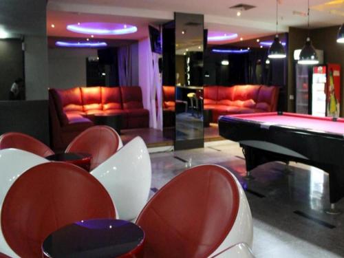 a room with a pool table and red chairs at The BCC Hotel & Residence in Nagoya