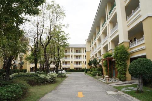 an empty street in front of a large building at The One Residence Hotel in Bangkok