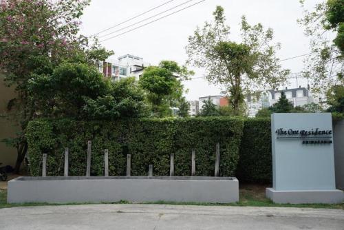 a sign sitting in front of a fence at The One Residence Hotel in Bangkok