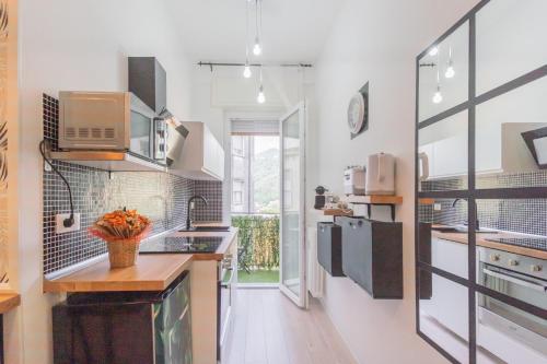 cocina con paredes blancas y suelo de madera en Casa di Silvia. Sei km da Como, en Lipomo