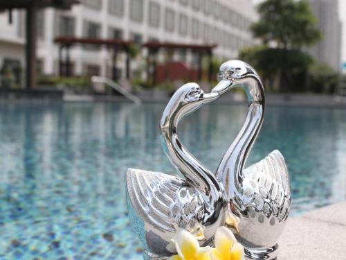 a metal bird statue next to a swimming pool at Jiaxin Conifer Hotel Shunde in Shunde