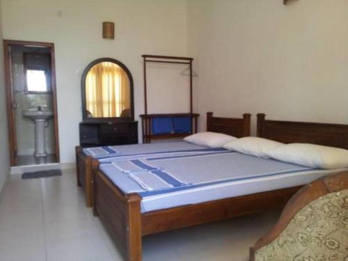 a bedroom with a large bed and a mirror at Dads Holiday Home in Matale