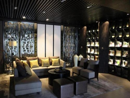 a living room with a couch and chairs and wine racks at H Life Hotel Nanshan Branch in Shenzhen