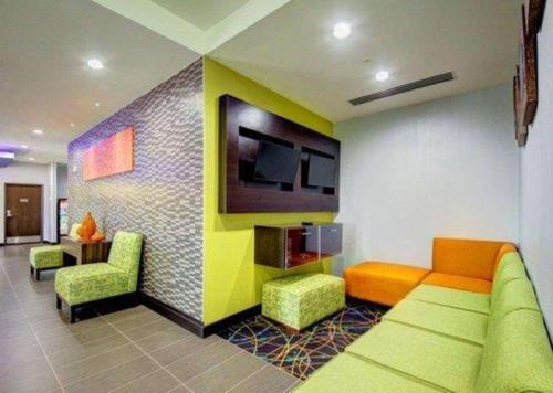a living room with a couch and chairs and a tv at Comfort Inn & Suites Tulsa I-44 West - Rt 66 in Tulsa