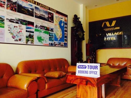 a living room with a couch and a sign on a table at Viet Village Hotel in Hanoi