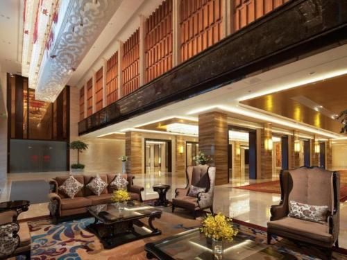 a lobby with couches and chairs and a table at Xi'an Airport Hotel in Xi'an