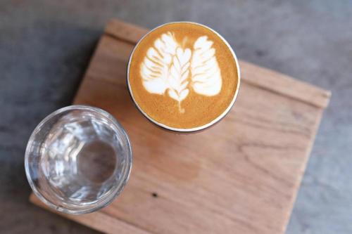 a cup of coffee next to a glass of water at Urban House 195 in Chiang Mai