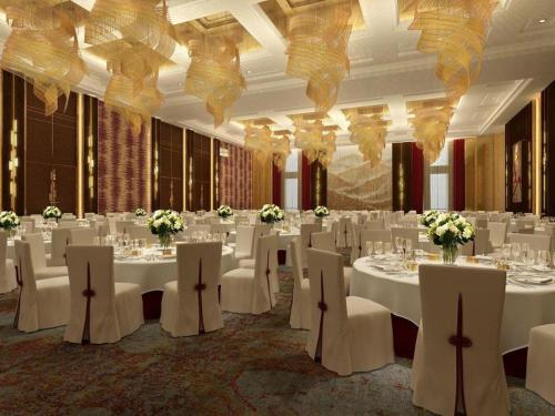 a banquet hall with white tables and white chairs at AOLUGUYA in Harbin