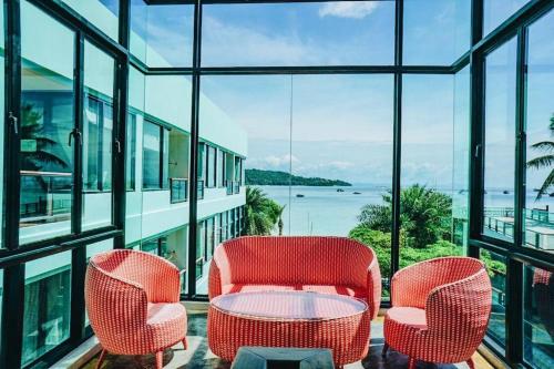 two chairs and a table in a room with windows at Phi Phi Nice Beach Hotel Hip in Phi Phi Don