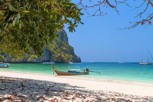 a boat on a beach near the ocean at Phi Phi Nice Beach Hotel Hip in Phi Phi Don