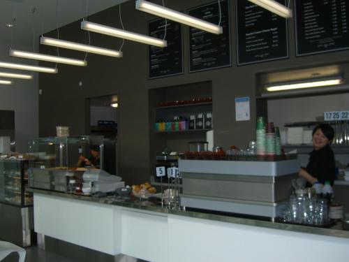 a woman standing at the counter of a fast food restaurant at Quest Carlaw Park Serviced Apartments in Auckland
