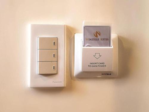una presa elettrica su un muro accanto a una scatola elettrica di Winzelle Suites a Zamboanga