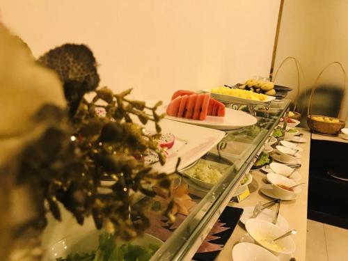 a buffet line with plates of food on a table at Lenid Hotel Tho Nhuom in Hanoi