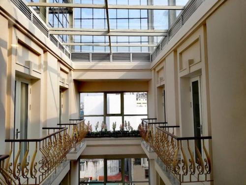 a hallway with stairs in a building with windows at Lenid Hotel Tho Nhuom in Hanoi