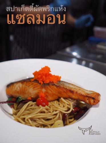 a plate of food with a piece of fish on pasta at The Buffalo Amphawa in Samut Songkhram