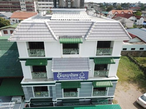 a white building with a sign on it at Thanyachatra Boutique. in Phetchaburi