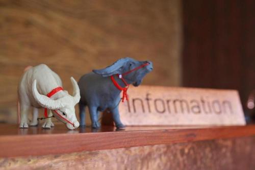two figurines of an elephant and a bull on a shelf at The Buffalo Amphawa in Samut Songkhram