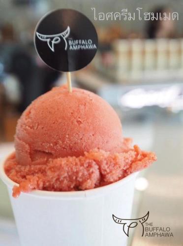 a red ice cream in a cup with a sign on it at The Buffalo Amphawa in Samut Songkhram