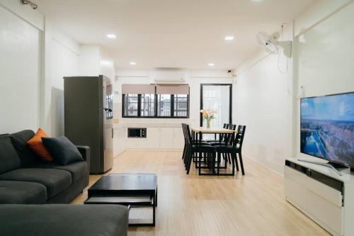 a living room with a couch and a table with chairs at Hidden Home Oldtown in Chiang Mai