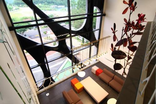 a room with a balcony with a couch and a table at KT&G Sangsangmadang Chuncheon Stay (Korea Quality) in Chuncheon