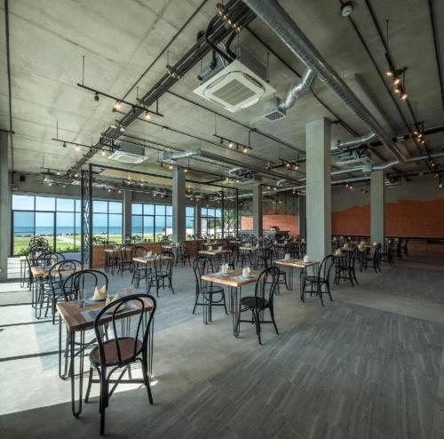 a dining room with tables and chairs in a building at i Tara Private in Phetchaburi