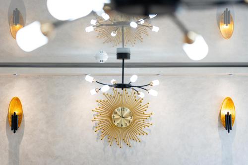 a chandelier with a clock on a wall with lights at Villa Sonja Apartments in Krasici