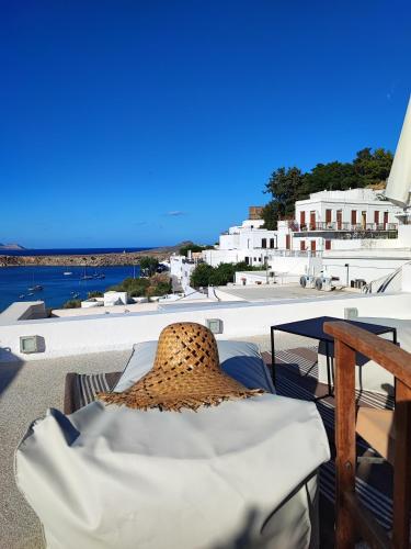 a straw hat sitting on top of a table on a balcony at Unique Stes Lindos in Líndos