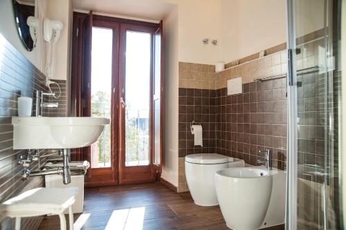 a bathroom with two toilets and a sink and a shower at La Locanda di Mariella dal 1950 in Poggio Picenze