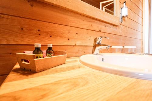 a bathroom with a sink and two bottles of beer at Domaine de l'Adoux in Saint-Jean Montclar