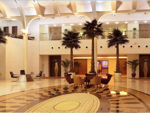 una hall con palme in un edificio di Shanxi World Trade Hotel a Taiyuan
