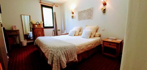 a bedroom with a bed and a table and a window at Domaine de l'Adoux in Saint-Jean Montclar