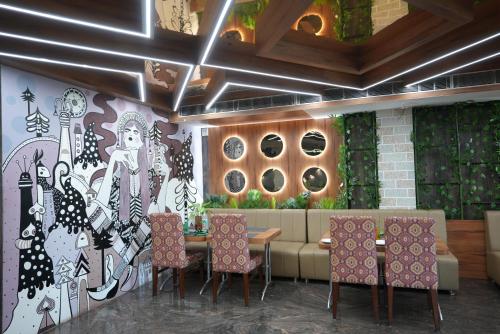 a restaurant with a table and chairs and a couch at Pipul Utkal Continental in Jhārsuguda