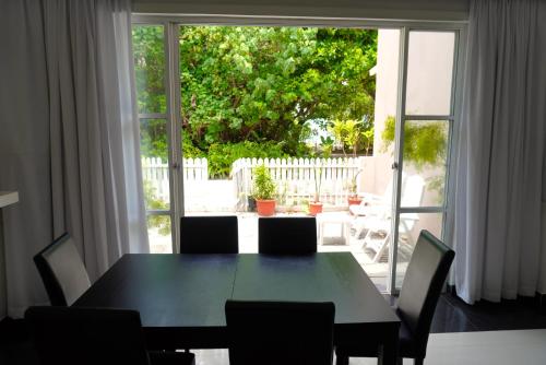 a dining room table and chairs in front of a large window at TME Retreats Dhigurah in Dhigurah