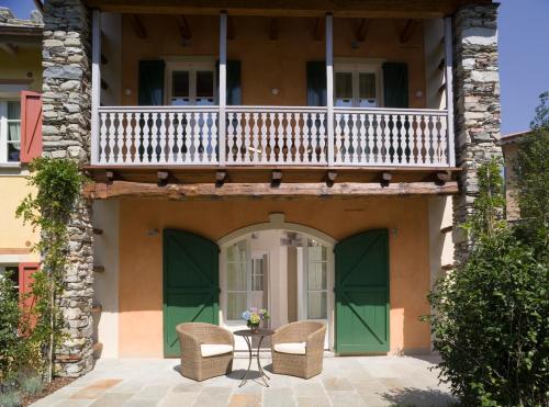 a patio with chairs and a balcony on a house at Park Hotel Villa Belvedere in Cannobio
