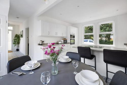 a dining room with a table and chairs and a kitchen at Park View House Close to Central Park and Plymouth Argyle FC - Dogs welcome - Hosted by Absolute Accommodation Plymouth in Plymouth