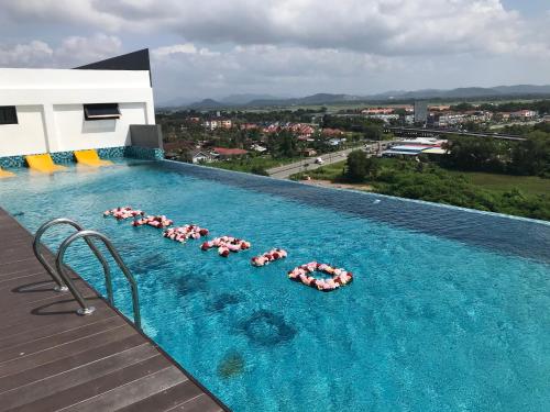 a swimming pool with a bunch of umbrellas in it at Homie 3 Rooms airconds with living hall aircond with pool and free wifi - 500meter from Hospital Sultanah Bahiyah Alor Setar Kedah in Kampong Masjid